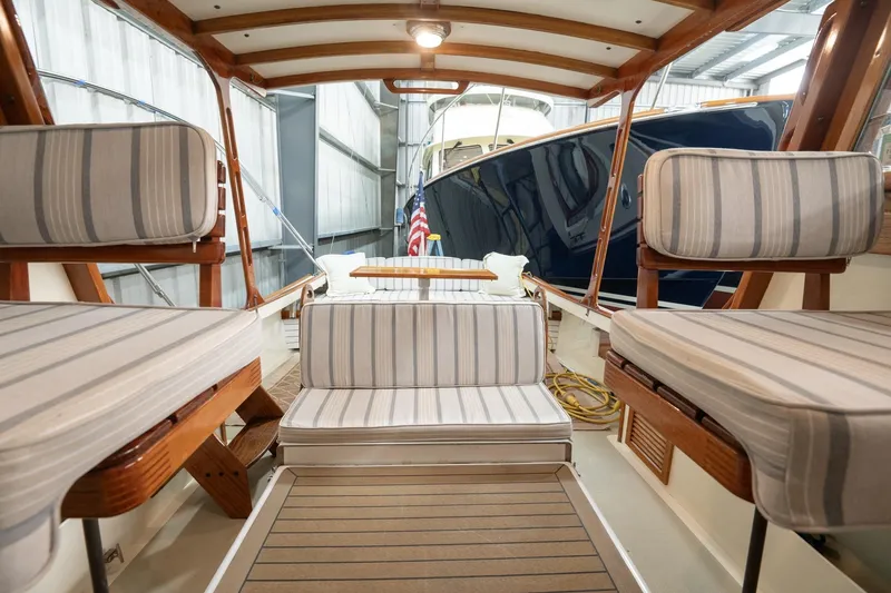 Slide: The Image of 1986 Dyer Hardtop boat interior with striped seating and wooden accents in a marina setting. - 18