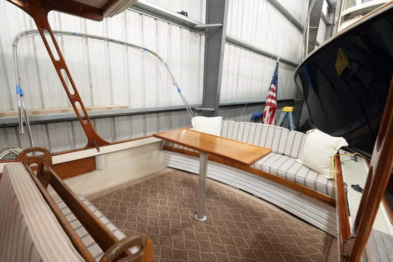Slide: The Image of 1986 Dyer Hardtop boat interior with striped seating, wooden table, and American flag. - 19