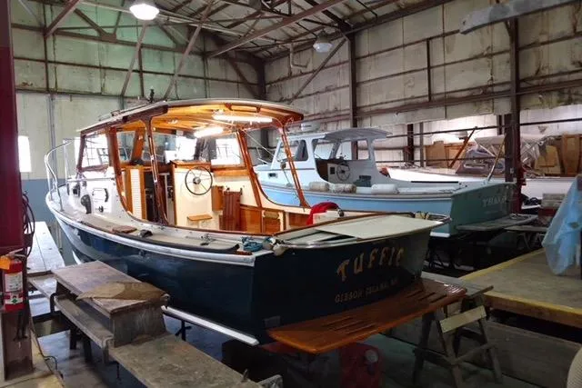 Slide: The Image of 1986 Dyer Hardtop boat in a workshop, showcasing classic design and wooden interior. - 2