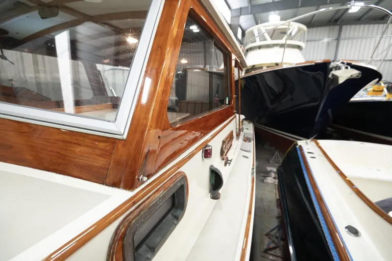 Slide: The Image of 1986 Dyer Hardtop boat in storage, showcasing polished wood and sleek design. - 24