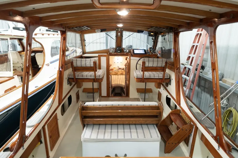 Slide: The Image of Interior of a 1986 Dyer Hardtop boat with wooden accents and cushioned seating. - 25