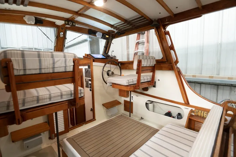 Slide: The Image of 1986 Dyer Hardtop boat interior with striped seating and wooden accents. - 26