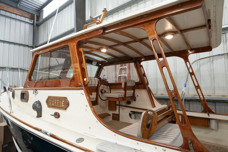 Slide: The Image of 1986 Dyer Hardtop boat with wooden interior, docked in a metal shed. - 30