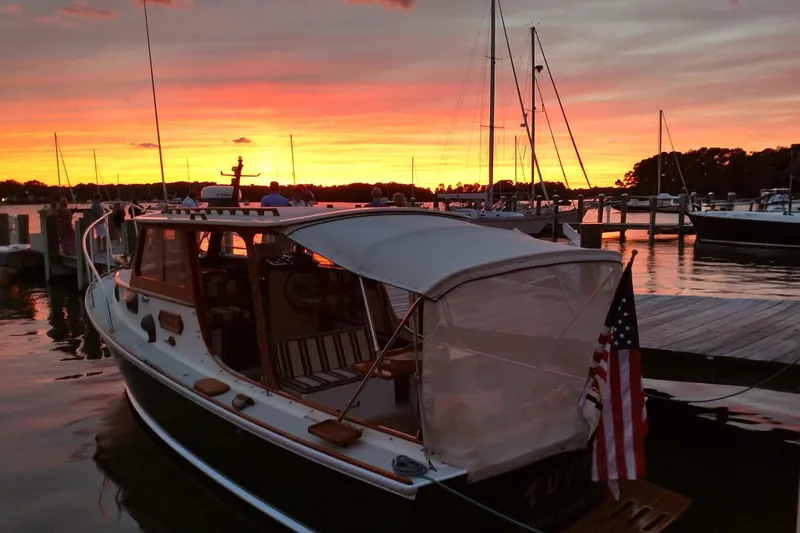 Slide: The Image of 1986 Dyer Hardtop boat docked at sunset with vibrant sky and American flag. - 40