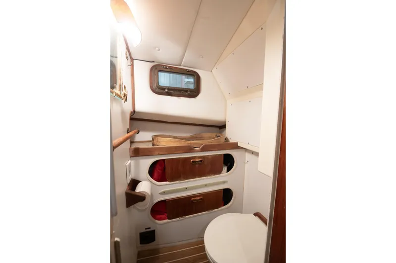 Slide: The Image of 1986 Dyer Hardtop boat interior with wooden storage and compact toilet. - 8