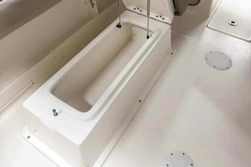 Slide: The Image of 2023 Key West 239 DFS boat interior with storage compartment and clean white deck. - 15