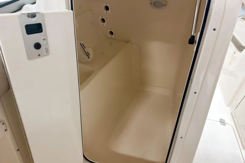 Slide: The Image of Interior view of 2023 Key West 239 DFS boat compartment, featuring storage space and control panel. - 16