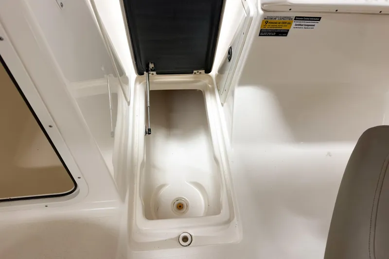 Slide: The Image of 2023 Key West 239 DFS boat storage compartment with open lid and seating area. - 21