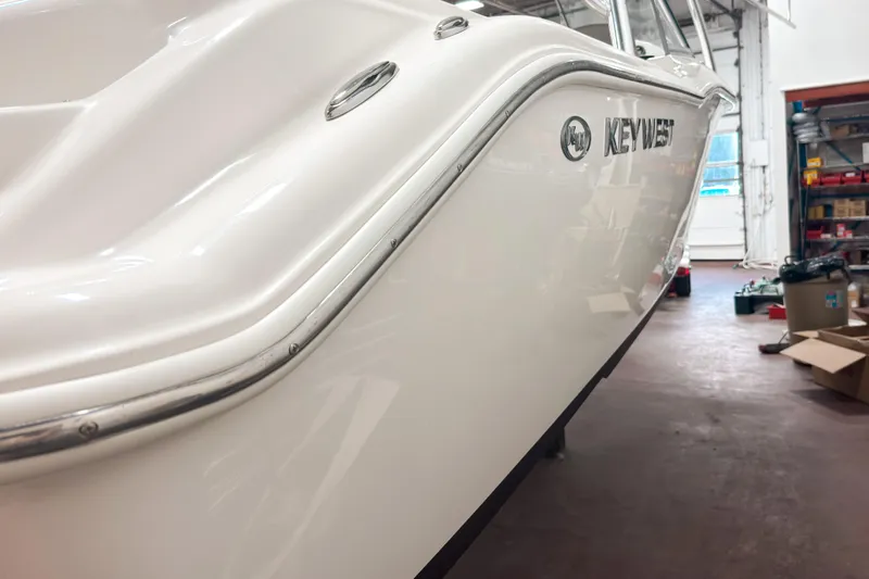 Slide: The Image of 2023 Key West 239 DFS boat in a workshop, showcasing sleek white hull design. - 5