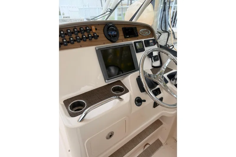 Slide: The Image of 2015 Grady-White Freedom 335 helm with steering wheel and navigation controls. - 12