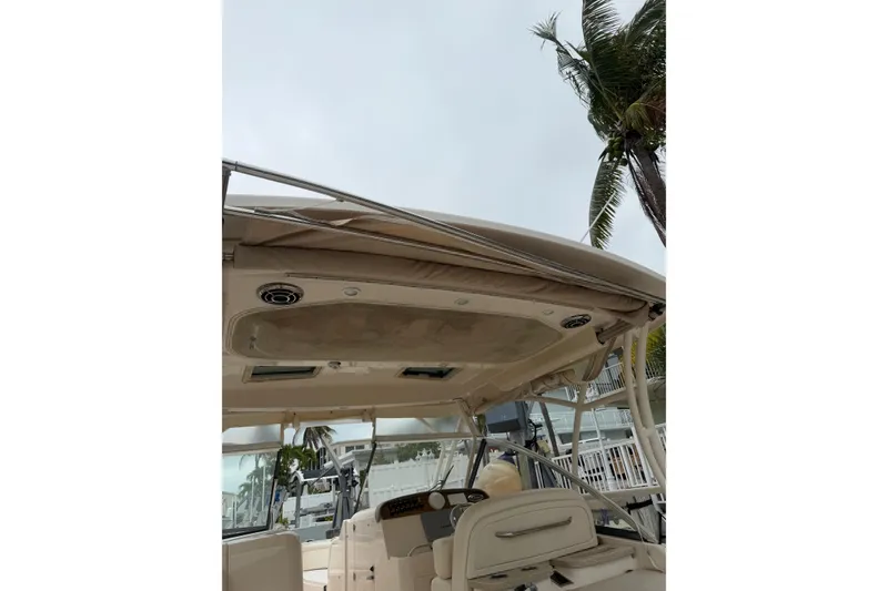 Slide: The Image of 2015 Grady-White Freedom 335 boat interior with canopy and palm tree background. - 21