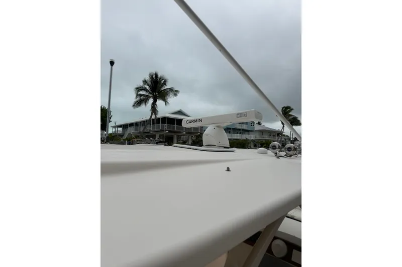 Slide: The Image of 2015 Grady-White Freedom 335 boat with Garmin radar, palm tree, and cloudy sky. - 24