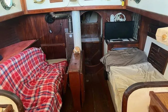 Slide: The Image of 1979 Bristol Channel Cutter interior with cozy seating, plaid blanket, and small TV setup. - 13