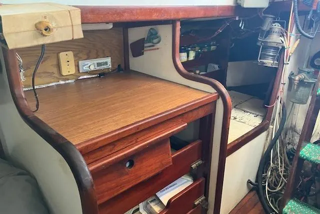 Slide: The Image of 1979 Bristol Channel Cutter interior with wooden desk, drawers, and nautical equipment. - 15