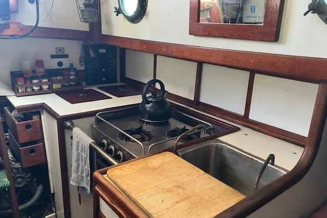 Slide: The Image of 1979 Bristol Channel Cutter kitchen with stove, sink, and wooden accents. - 16