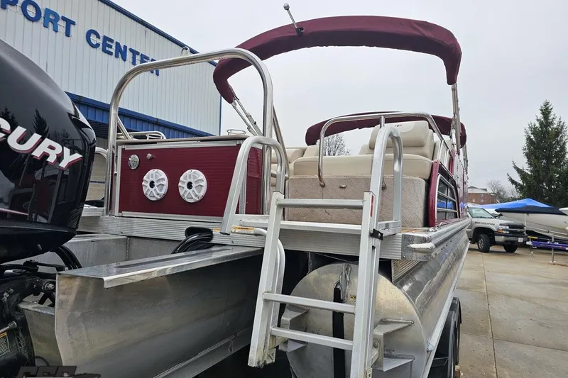 Slide: The Image of 2012 Tahoe Pontoon Vision 25' boat with Mercury engine at a port center. - 12