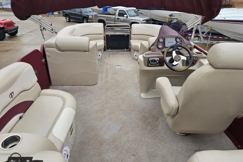 Slide: The Image of 2012 Tahoe Pontoon Vision 25' interior with beige seating and steering console. - 27