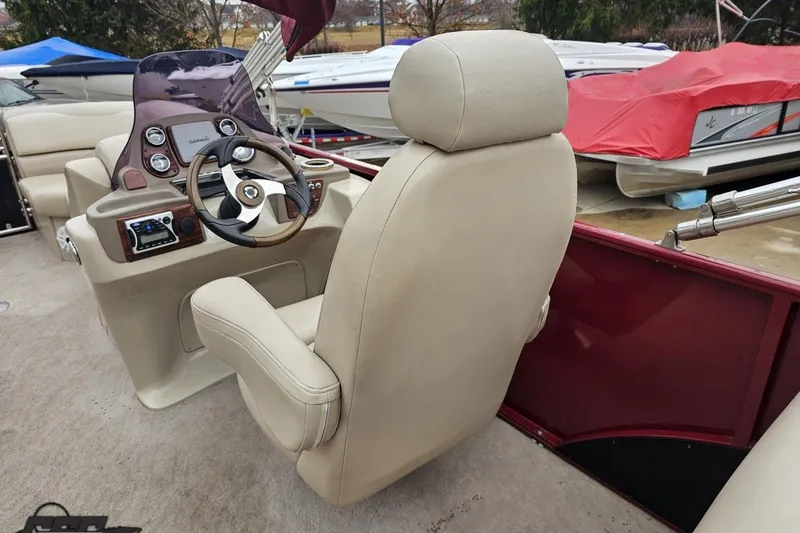 Slide: The Image of 2012 Tahoe Pontoon Vision 25' helm with beige captain's chair and steering wheel. - 34