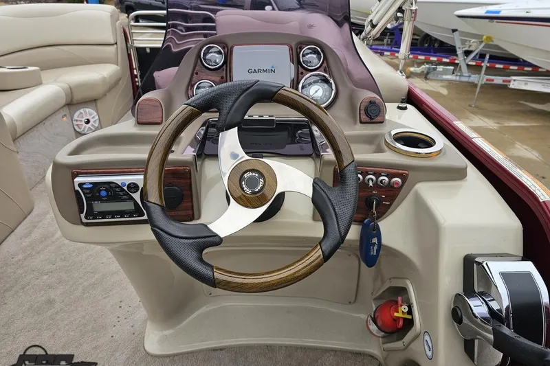 Slide: The Image of 2012 Tahoe Pontoon Vision 25' boat dashboard with steering wheel and Garmin navigation system. - 38