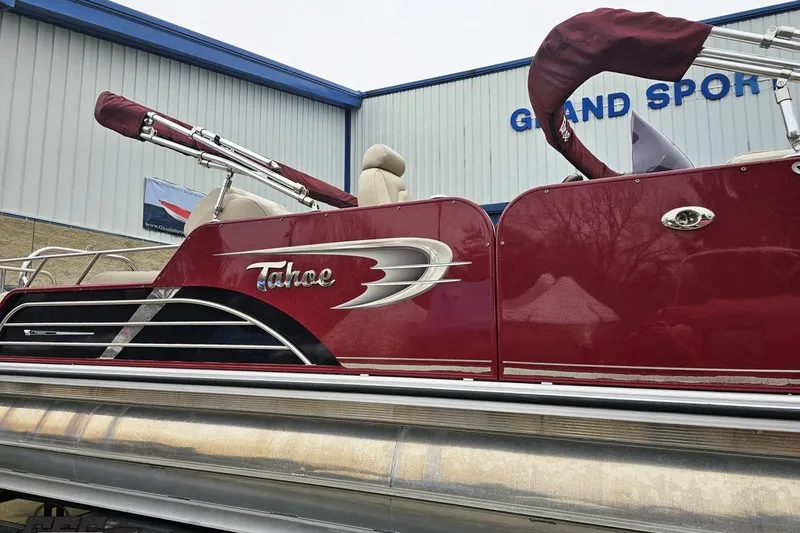Slide: The Image of 2012 Tahoe Pontoon Vision 25' boat with maroon exterior at Grand Sport facility. - 5