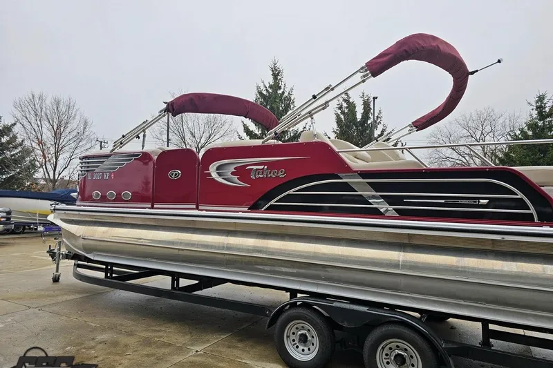 Slide: The Image of 2012 Tahoe Pontoon Vision 25' boat on trailer, featuring red and silver design. - 9