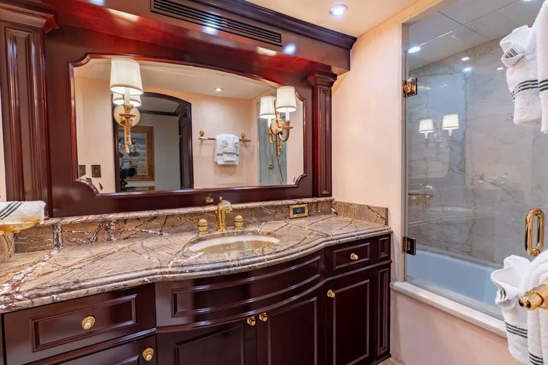 Slide: The Image of Luxurious yacht bathroom with marble countertop and elegant wooden cabinetry, Trinity Tri-Deck Motor Yacht 2006. - 16