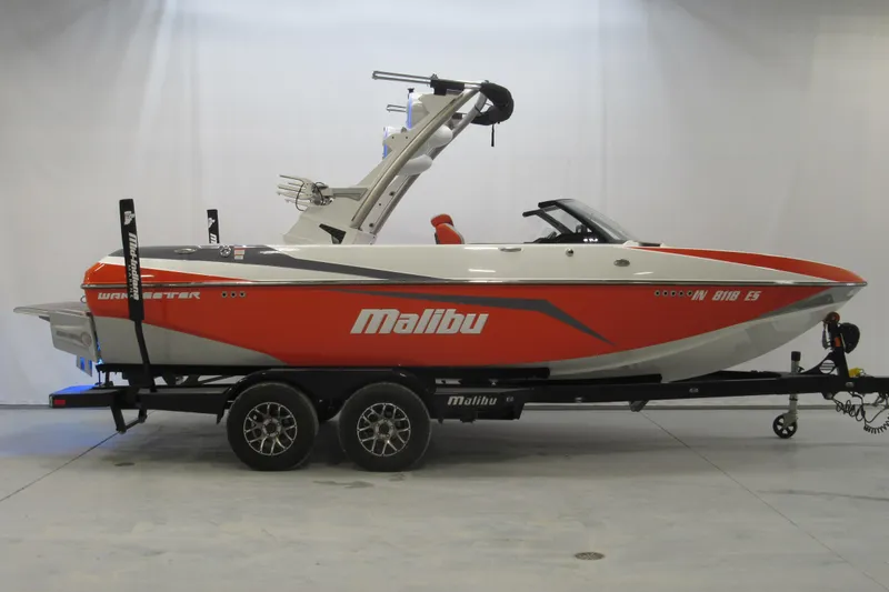 The Image of 2021 Malibu Wakesetter 21 VLX boat on trailer, red and white design. - 0