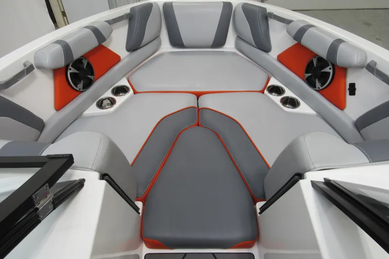 Slide: The Image of 2021 Malibu Wakesetter 21 VLX interior with gray and orange seating, cup holders, and speakers. - 8