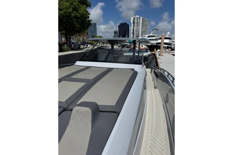 Slide: The Image of 2023 Canados 431 yacht docked, featuring sleek design and luxurious sunbathing area. - 18