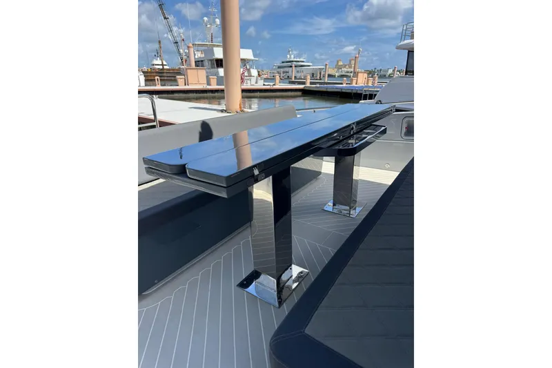 Slide: The Image of Modern Canados 431 yacht deck with sleek, reflective table and luxurious seating, 2023 model. - 25
