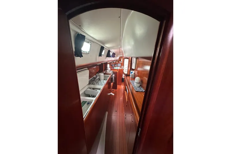 Slide: The Image of Interior view of 2005 Beneteau Oceanis 42CC sailboat, featuring a sleek wooden galley. - 14