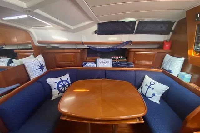 Slide: The Image of Cozy interior of 2005 Beneteau Oceanis 42CC sailboat with nautical-themed cushions. - 2