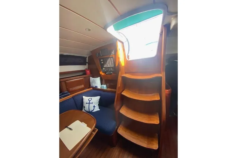 Slide: The Image of Interior of 2005 Beneteau Oceanis 42CC sailboat with wooden stairs and cozy seating area. - 22