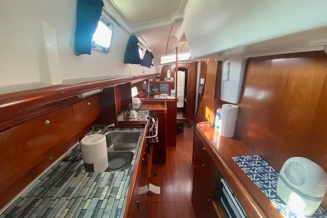 Slide: The Image of Interior of 2005 Beneteau Oceanis 42CC yacht with wooden cabinetry and modern kitchen amenities. - 5