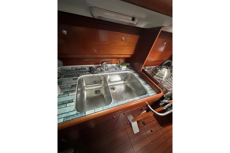 Slide: The Image of Galley sink in 2005 Beneteau Oceanis 42CC yacht with wooden cabinetry and tiled countertop. - 6
