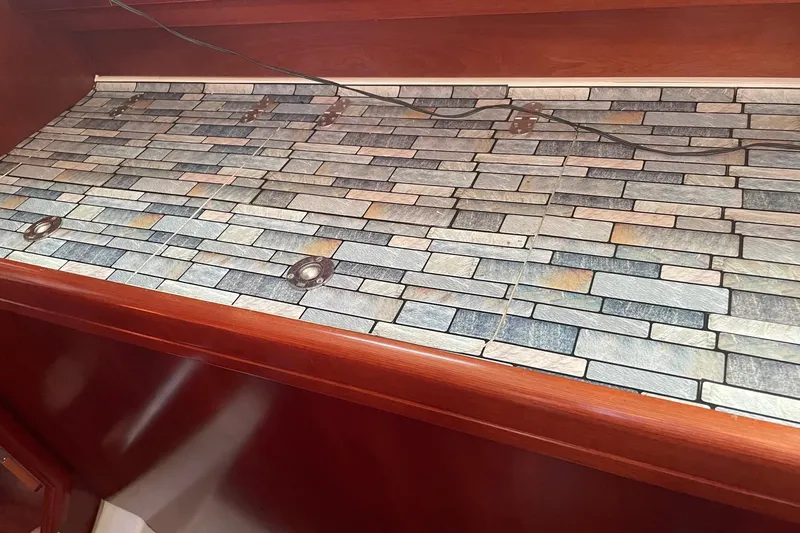 Slide: The Image of Interior of 2005 Beneteau Oceanis 42CC with stone-patterned countertop and wooden trim. - 8