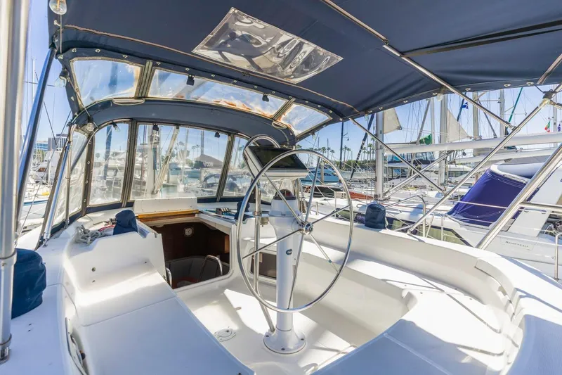 Slide: The Image of Cockpit of 2000 Hunter Passage 420 sailboat with steering wheel and marina view. - 11