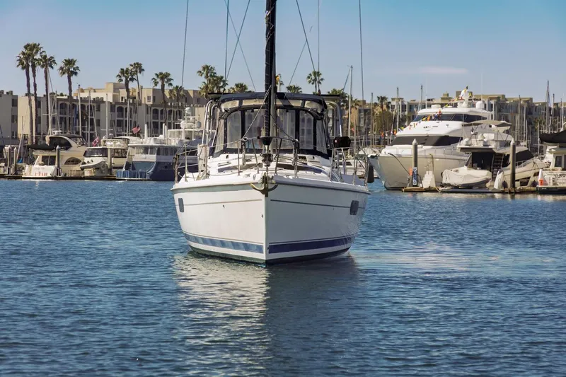 Slide: The Image of Hunter Passage 420 sailboat docked in marina, surrounded by yachts and palm trees. - 2