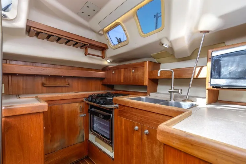 Slide: The Image of Interior of 2000 Hunter Passage 420 sailboat kitchen with wooden cabinetry and appliances. - 26