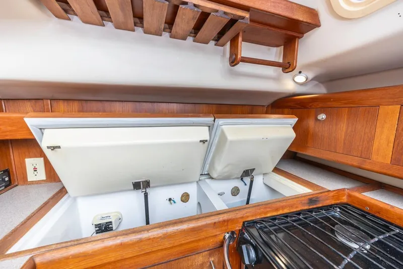 Slide: The Image of Interior of 2000 Hunter Passage 420 yacht showing open storage compartments and wooden cabinetry. - 27