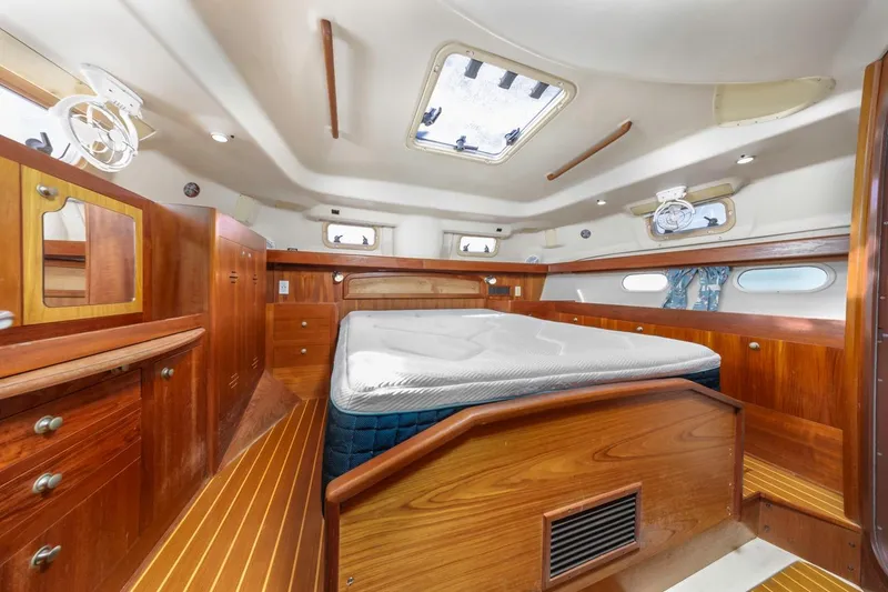 Slide: The Image of Interior of 2000 Hunter Passage 420 yacht with wooden cabinetry and a central bed. - 30