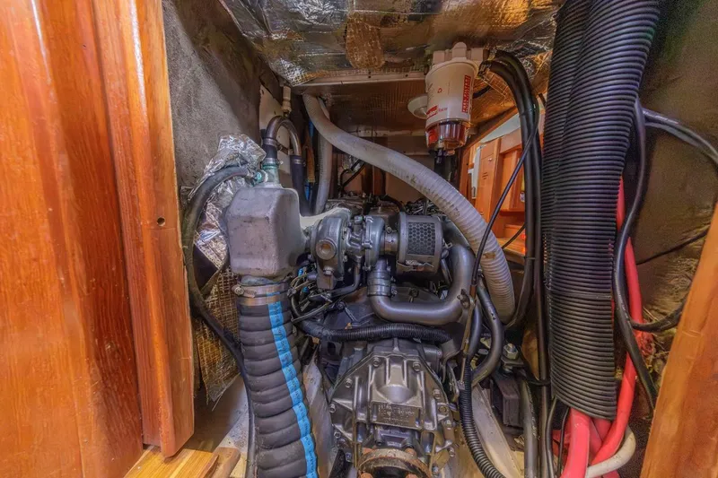 Slide: The Image of Engine compartment of a 2000 Hunter Passage 420 sailboat, showcasing mechanical components and wiring. - 34