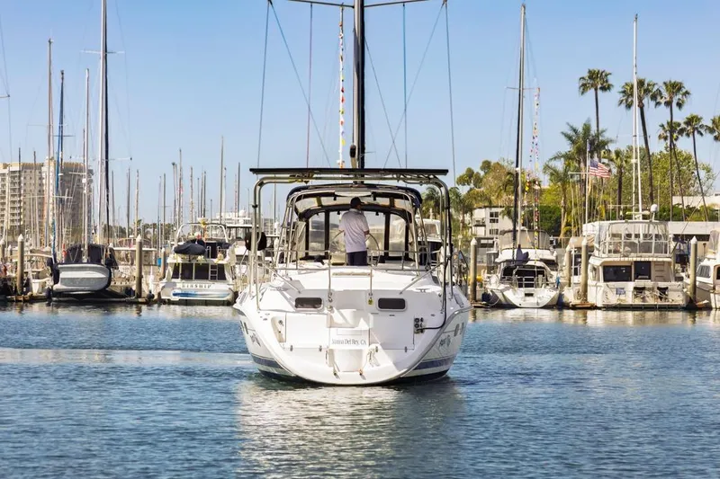 Slide: The Image of Hunter Passage 420 sailboat from 2000 navigating a marina with docked boats. - 5