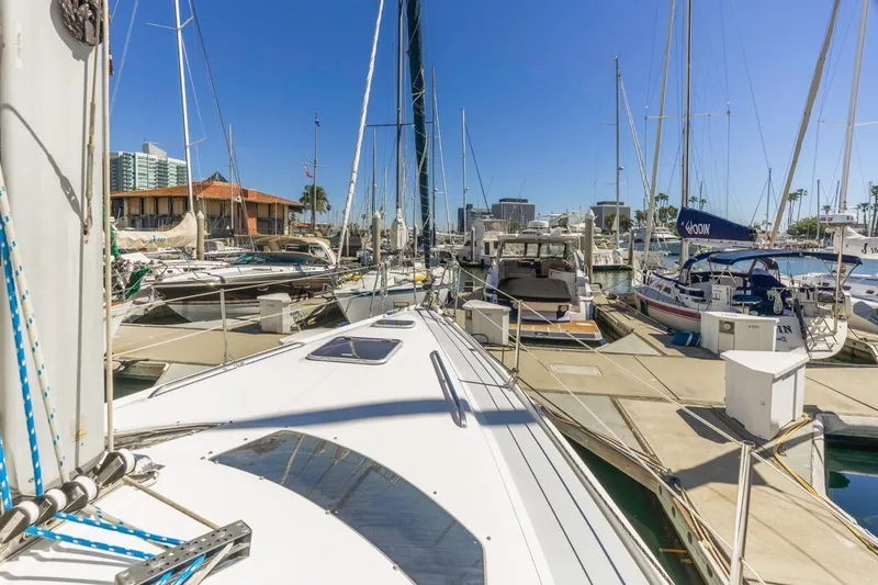 Slide: The Image of Hunter Passage 420 sailboat docked in a sunny marina, surrounded by other boats. - 6