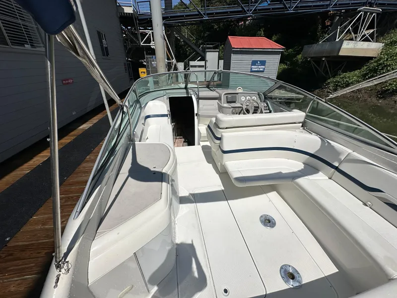 Slide: The Image of 2000 Formula 330 SS boat interior with white seating and control panel, docked near a building. - 11