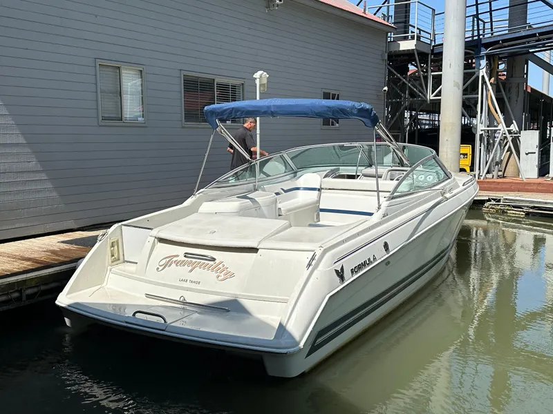 Slide: The Image of 2000 Formula 330 SS boat docked with blue canopy and sleek design. - 3
