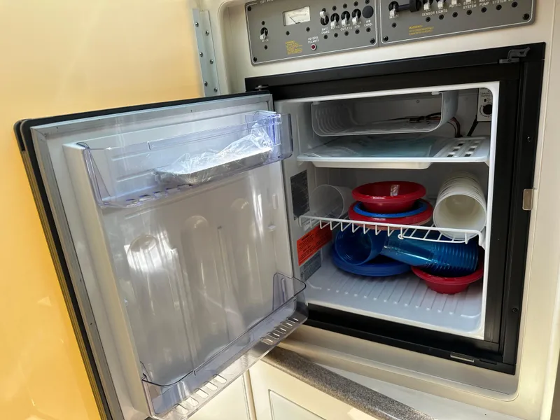 Slide: The Image of Open refrigerator in a Formula 330 SS boat, showing shelves with plastic containers. - 37
