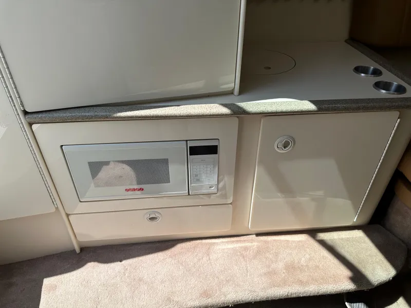 Slide: The Image of Interior of a 2000 Formula 330 SS boat featuring a built-in microwave and storage cabinets. - 38