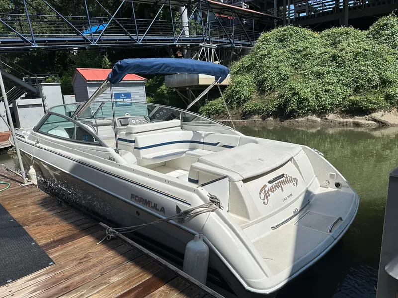 Slide: The Image of 2000 Formula 330 SS boat docked, featuring a sleek design and blue canopy. - 6