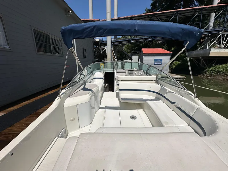 Slide: The Image of 2000 Formula 330 SS boat with blue canopy, docked near a building. - 9